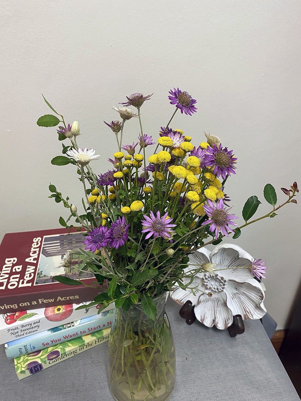Vase containing paper flowers and other varieties to make a bouquet.